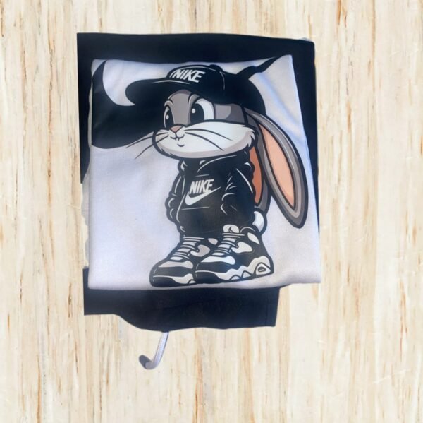 Camiseta blanca con un estampado de dibujos Looney Tunes y pantalones cortos negros.